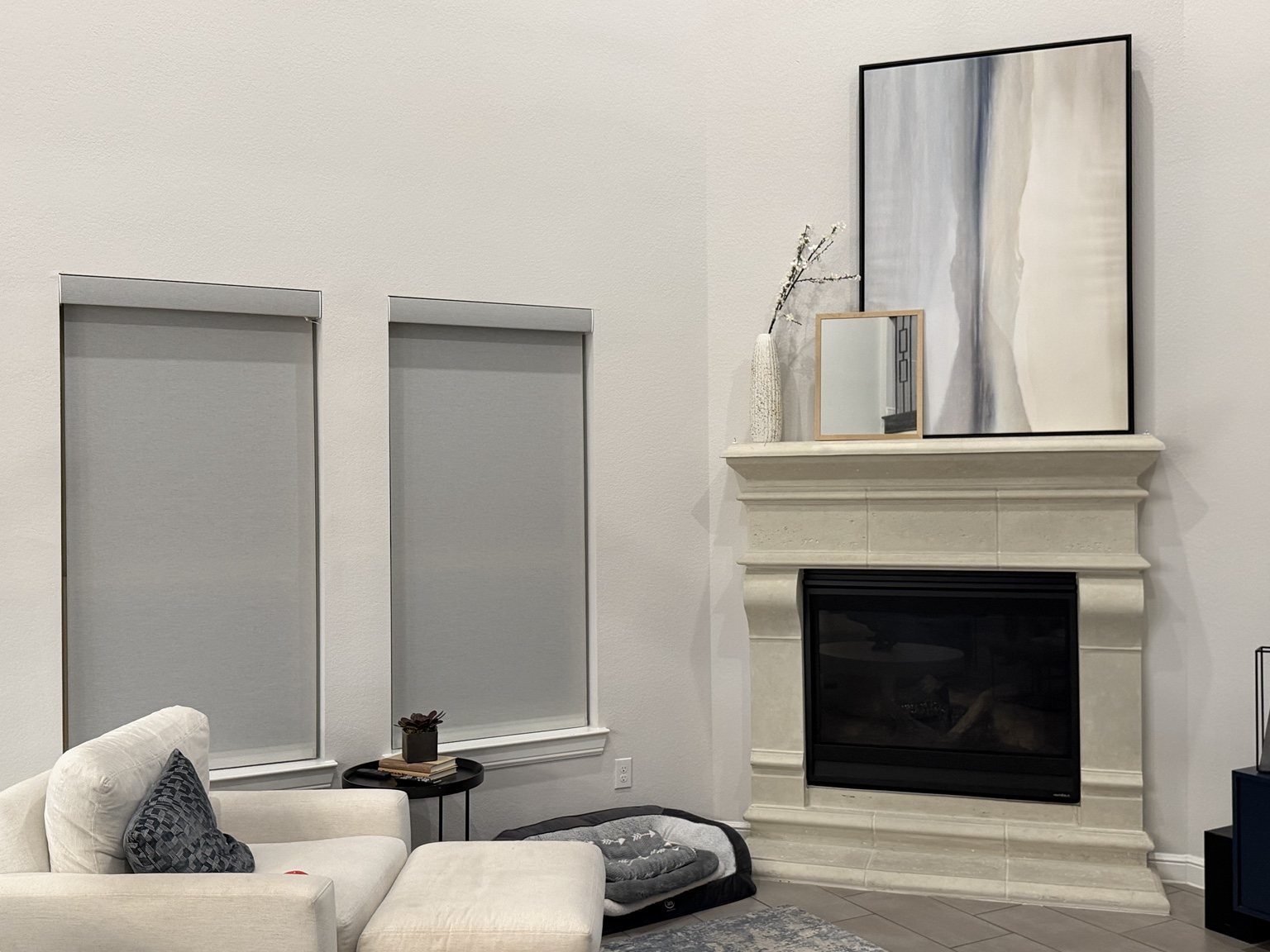 Custom roller shades installed beside a fireplace