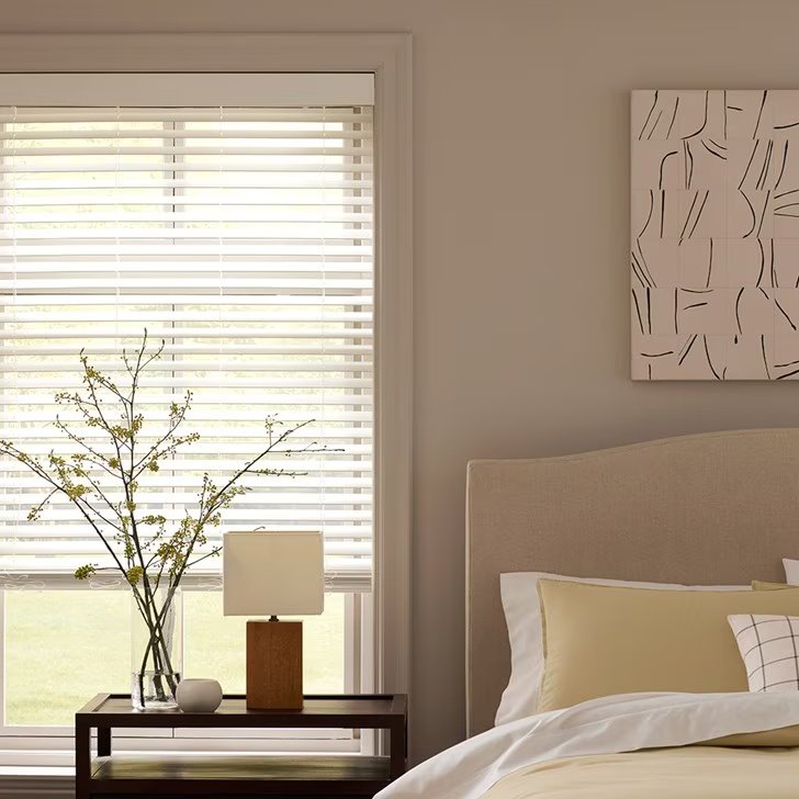 White faux wood blinds installed on a wide window