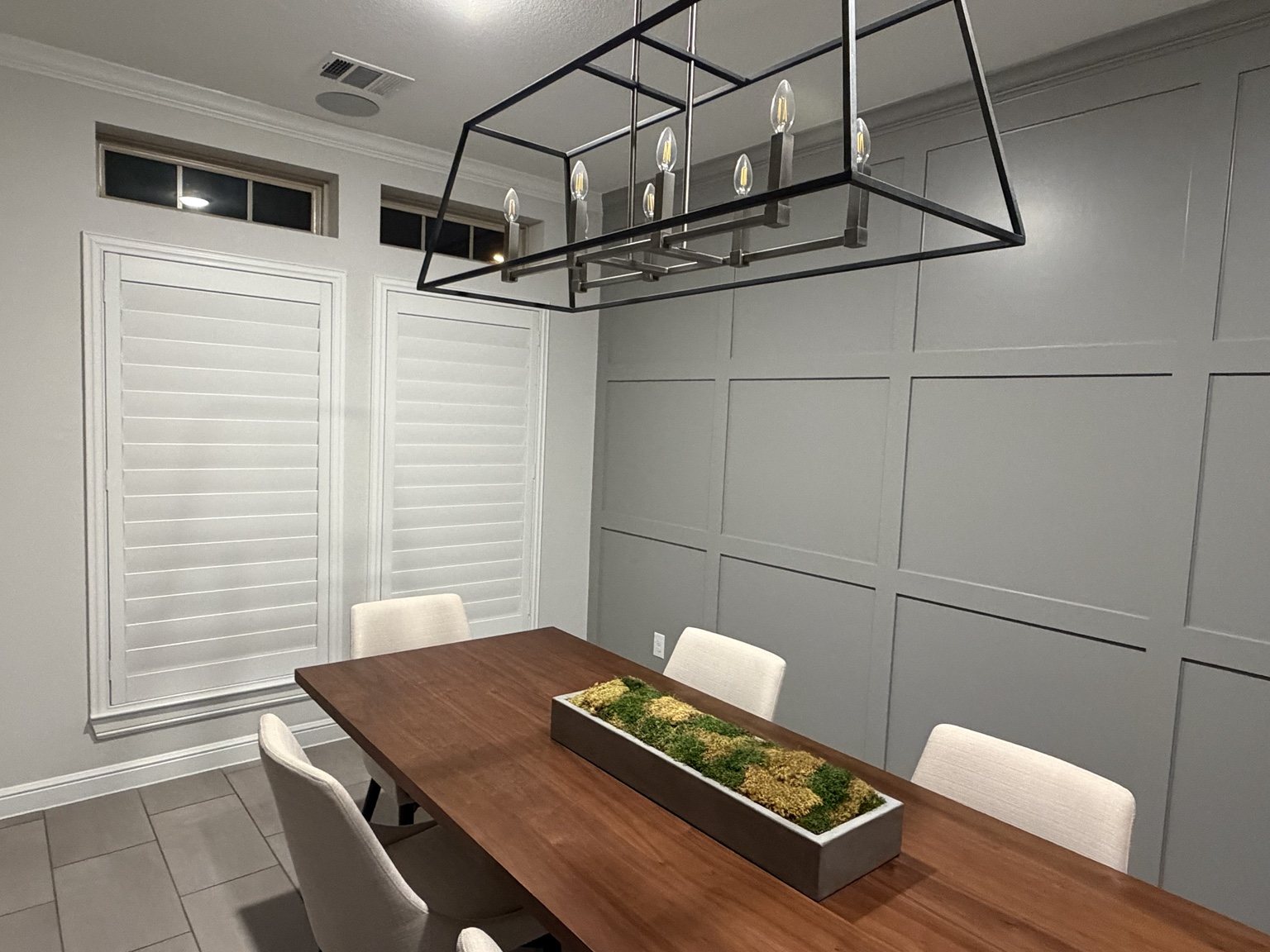 White plantation shutters on tall windows with transoms